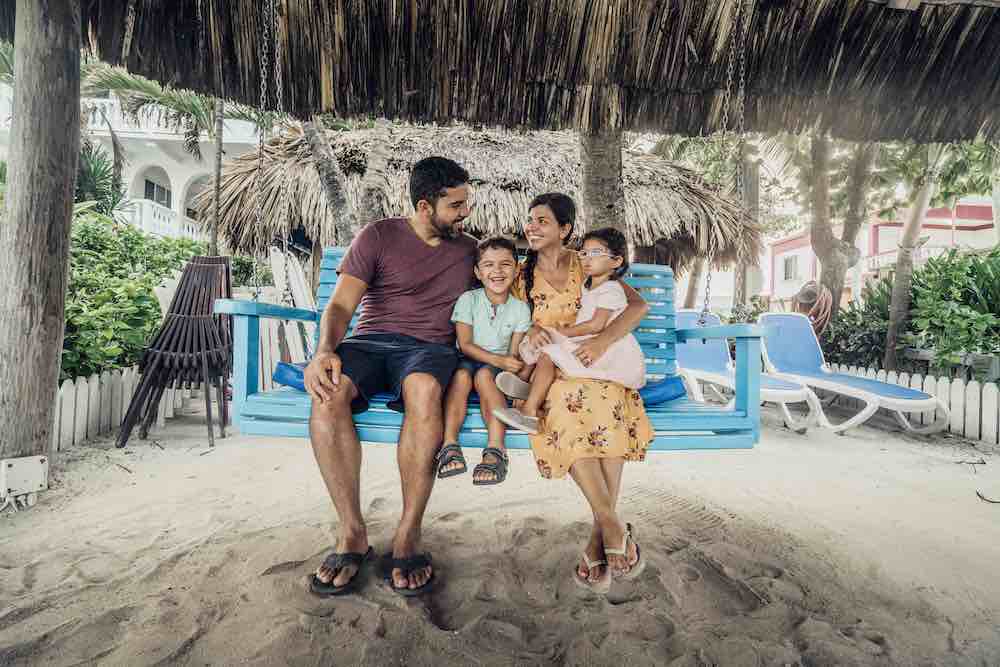 Family sitting on the swing at our Hotel in San Pedro, Belize - one of the best Caribbean destinations for families.